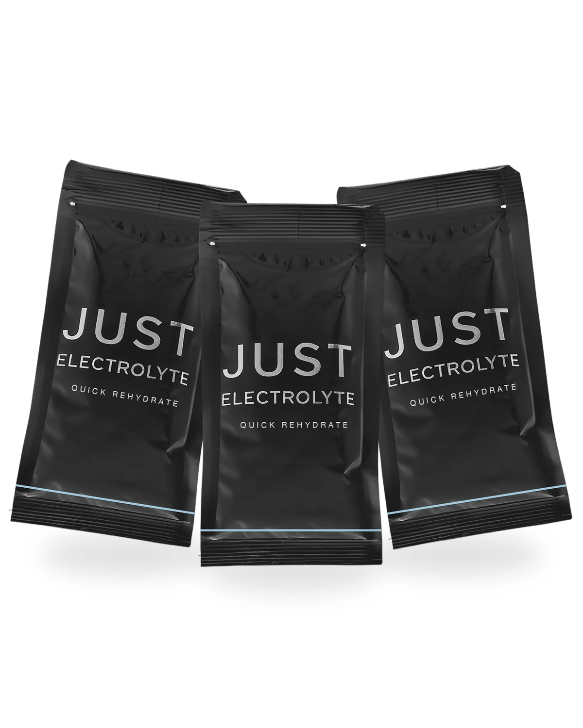 Three matte-black Just Electrolyte Quick Rehydrate single-serve sachets fanned standing, close-up detail with 'JUST ELECTROLYTE' wordmark